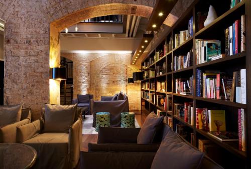 a library with couches and bookshelves at Harbour Rocks by Ode Hotels in Sydney