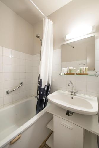 une salle de bain blanche avec un lavabo et une baignoire dans l'établissement Le Moulin de Sournia, à Sournia