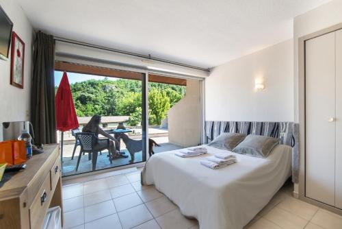 - une chambre avec un lit et une vue sur une terrasse dans l'établissement Le Moulin de Sournia, à Sournia