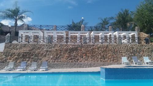 a group of chairs sitting next to a swimming pool at African Rest Lodge in Barberton