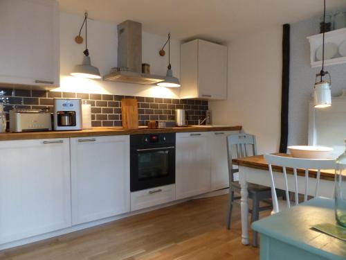 a kitchen with white cabinets and a wooden table at Feine Laube in Berlin