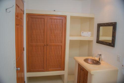 a bathroom with a sink and a mirror at Bungalows Arena Dorada in Zihuatanejo