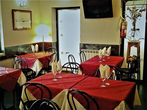 un comedor con 2 mesas con mantel rojo en Hostal Martin - Sanabria, en Ribadelago
