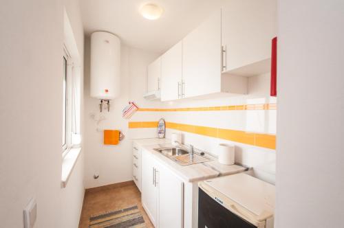a kitchen with white cabinets and a sink at Rivers Nation Surf Camp in Atouguia da Baleia