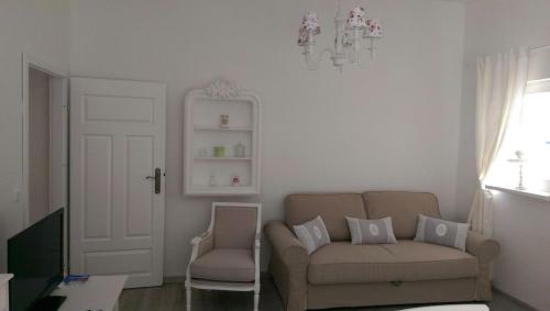 un salon avec un canapé et une chaise dans l'établissement Romantic Style Apartment Berlin, à Berlin