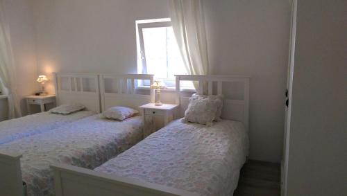 deux lits dans une chambre blanche avec une fenêtre dans l'établissement Romantic Style Apartment Berlin, à Berlin