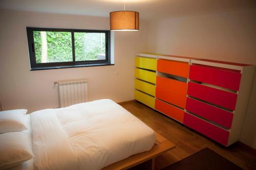a bedroom with a bed and a colorful dresser at Apartment with Garden and Pool in Estoril