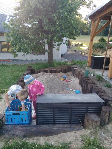 two young children playing in a sandbox in a sandbox at Apartmány Kuřátko in Benecko