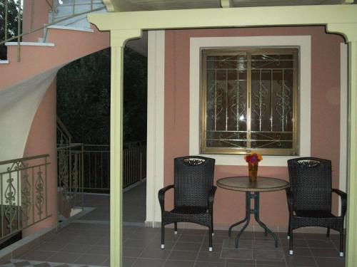 a patio with two chairs and a table and a window at Ramona in Lourdhata