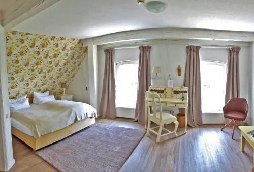 ein Schlafzimmer mit einem Bett und einem Schreibtisch mit einem Stuhl in der Unterkunft Landsitzhotel und Seminarium Peterhof in Hodorf