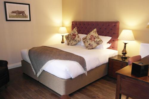um quarto com uma cama grande e 2 candeeiros em The Thomas Lord em West Meon