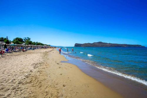 a beach with a crowd of people and the ocean at Eden Beach Hotel in Agia Marina Nea Kydonias
