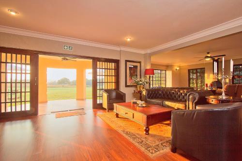 a living room with a couch and a table at Leopardsong Manor in Centurion