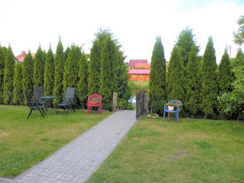 a garden with chairs and tables in the grass at Pokoje Żabi Staw in Mikołajki