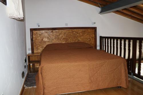a bedroom with a bed with a wooden head board at AgroSpito Traditional Guest House in Agros