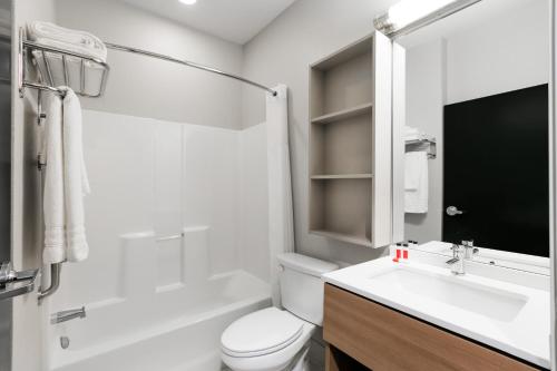 a white bathroom with a toilet and a sink at Microtel Inn and Suites by Wyndham Monahans in Monahans