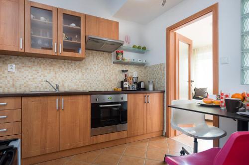 eine Küche mit Holzschränken und einer Arbeitsplatte in der Unterkunft Old Town Apartment Pellicova in Brünn