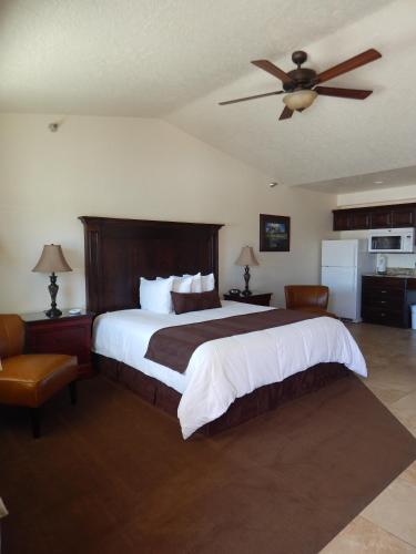 a bedroom with a large bed with a ceiling fan at Winterton Suites in Williston