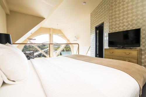 a bedroom with a white bed and a tv at Park Town Hotel in Saskatoon