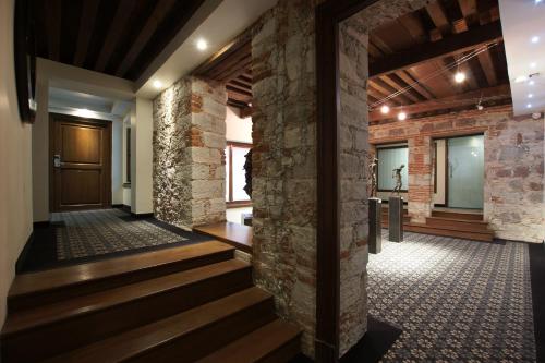a lobby with a stone wall and stairs at 1850 Hotel Boutique in Guanajuato