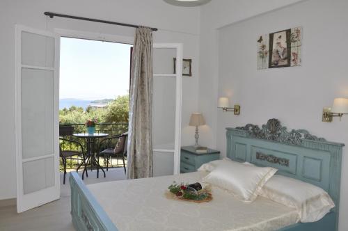a bedroom with a blue bed and a balcony at Braziliana Apartments Corfu in Dassia