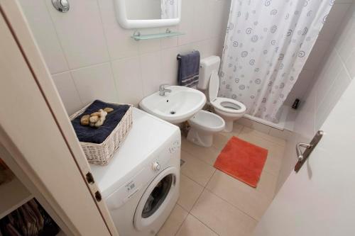 a bathroom with a washing machine and a sink at Sunny apartment in Zadar