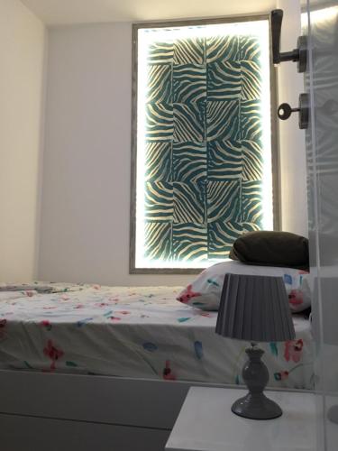 a bedroom with a bed with a window and a lamp at Squere 44 Apartment in Budva