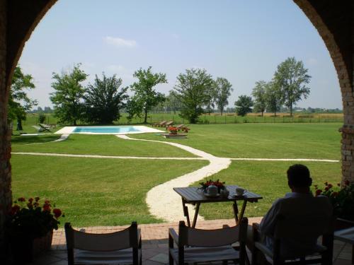 a man sitting at a table looking out at a park at Il Rifugio del Poeta in San Biagio di Callalta