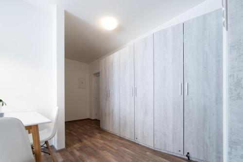 a room with white cabinets and a table at MyApartment in the city center in České Budějovice