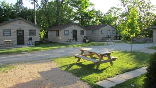 a picnic table in the grass in front of a house at The Maples Cottages in Port Elgin in Port Elgin