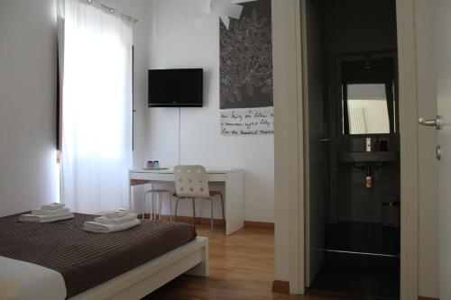 a bedroom with a bed and a desk and a window at I'MC IoAMoCagliari in Cagliari