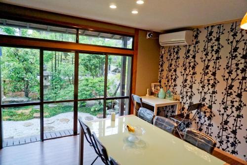ein Esszimmer mit einem Tisch und einem Fenster in der Unterkunft Kinkaku in Kyoto