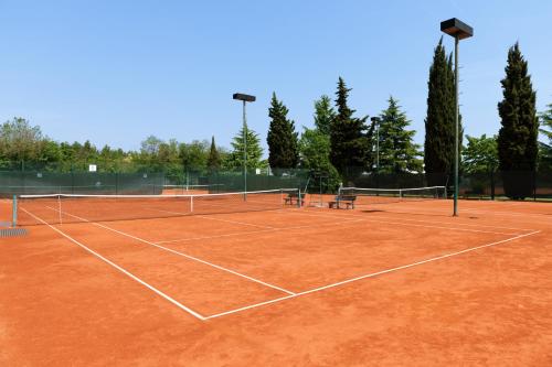 a tennis court with two benches on it at Eden Hotel by Maistra Collection in Rovinj