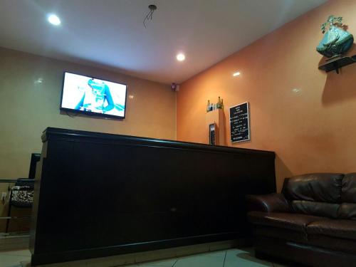 une salle d'attente avec une télévision murale à écran plat dans l'établissement Hotel San Salvador, à San Juan de los Lagos