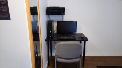 a desk with a computer and a chair in a room at Sunset Motel in Cache Creek