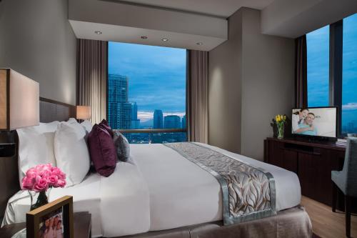 a bedroom with a large bed with a large window at Ascott Kuningan Jakarta in Jakarta