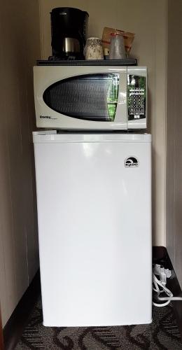 a microwave sitting on top of a white refrigerator at Holiday Motel & RV Resort in Hope