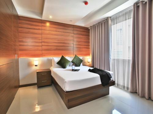 A bed or beds in a room at Valero Grand Suites by Swiss-Belhotel