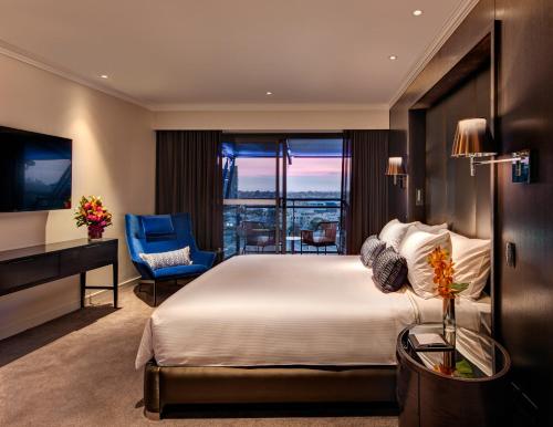 um quarto com uma cama grande e uma janela grande em The Star Grand Hotel and Residences Sydney em Sydney