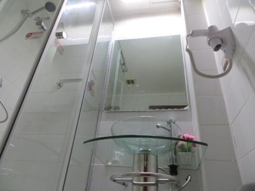 a bathroom with a glass sink and a mirror at Hotel Newen in Temuco