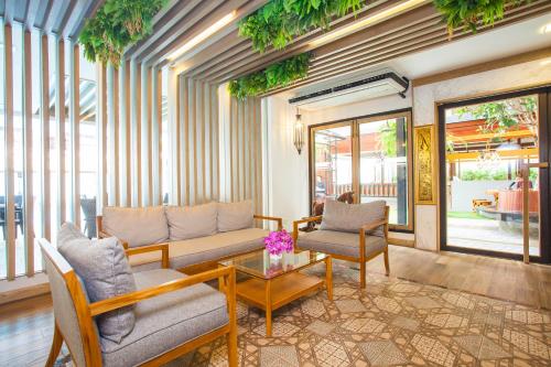 a living room with a couch and chairs and a table at New Siam Palace Ville Hotel in Bangkok