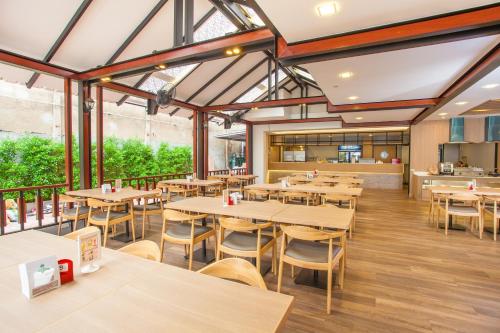 an empty restaurant with wooden tables and chairs at New Siam Palace Ville Hotel in Bangkok
