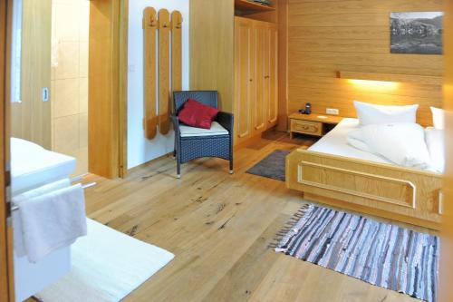 a bedroom with a bed and a chair and a desk at Pension Olympia in Oetz