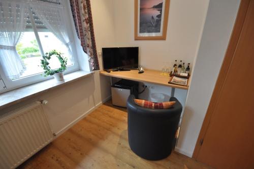 a room with a desk with a computer and a window at Landhaus Warndtwald in Wadgassen