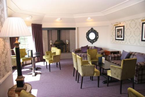 a hotel lobby with chairs and a table at Old Manor Hotel in Lundin Links