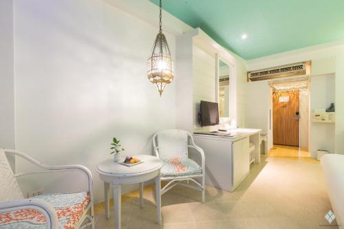 a living room with a table and chairs and a kitchen at The Verandah - SHA Extra Plus in Ao Nang Beach