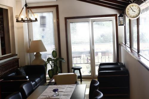 a living room with chairs and a clock on the wall at Elizabeth House in Skopje