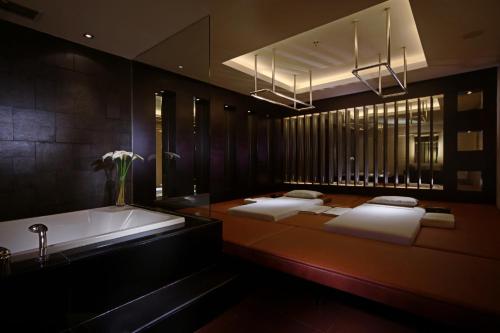 a bathroom with two beds and a bath tub at FM7 Resort Hotel - Jakarta Airport in Tangerang