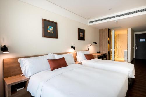 a hotel room with two beds in a room at Just Sleep Hualien ZhongZheng in Hualien City