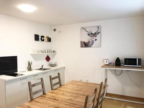 una cucina e una sala da pranzo con tavolo in legno di Lafri Apartment a Bolzano